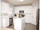 Bright kitchen featuring white cabinetry, stainless steel appliances, and marble countertops at 10943 Pendragon Pl, Raleigh, NC 27614