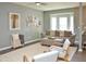 A living room with gray walls, light-colored furnishings, and a bay window at 10943 Pendragon Pl, Raleigh, NC 27614