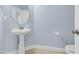 Powder room with pedestal sink, round mirror, and blue walls at 11 Glen Valley Ct, Angier, NC 27501