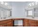 A bathroom vanity and corner with dual sinks and mirrors and custom wood cabinets at 11 Glen Valley Ct, Angier, NC 27501