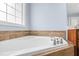 A close up of the tub in the bathroom with decorative tile and fixtures under the window at 11 Glen Valley Ct, Angier, NC 27501