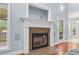 Living room fireplace with white mantel, decorative tile and door to outside deck at 11 Glen Valley Ct, Angier, NC 27501