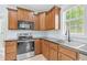 Kitchen featuring wood cabinets, stainless steel appliances, and tile flooring under a window with natural light at 11 Glen Valley Ct, Angier, NC 27501