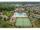 Aerial shot of community clubhouse with pool, tennis courts, and playground surrounded by lush greenery at 1109 Renewal Pl, Raleigh, NC 27603