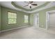 Spacious bedroom with tray ceiling, ceiling fan, carpeted floors, and natural light at 1109 Renewal Pl, Raleigh, NC 27603