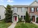 Charming townhome featuring gray siding, a bright red front door, and manicured landscaping at 1109 Renewal Pl, Raleigh, NC 27603