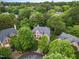 Aerial view of a beautiful brick home nestled among lush green trees in a quiet, upscale neighborhood setting at 111 Murdock Creek Ct, Cary, NC 27519