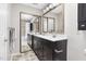 Spacious bathroom featuring a double sink vanity with a dark cabinet, a large mirror, and a combination tub and shower at 111 Sir Richard Ln, Chapel Hill, NC 27517