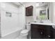 Bright bathroom featuring white tiled walls, a dark vanity, and a shower-tub combination with a shower curtain at 111 Sir Richard Ln, Chapel Hill, NC 27517