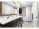 Bathroom featuring a double sink vanity with dark cabinetry, a large mirror, and a tiled shower with a shower curtain at 111 Sir Richard Ln, Chapel Hill, NC 27517