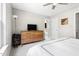 Well-lit bedroom featuring a modern dresser, a TV, and a view into an ensuite bathroom with a toilet at 111 Sir Richard Ln, Chapel Hill, NC 27517