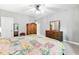 Bright bedroom features wooden furniture, ceiling fan, and neutral carpet at 11808 Venture Oak Way, Raleigh, NC 27613