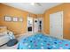 A bedroom with orange walls, a ceiling fan and adjoining bathroom and laundry room at 11808 Venture Oak Way, Raleigh, NC 27613