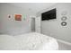 This bedroom has a large television mounted to the wall and art on the wall at 11808 Venture Oak Way, Raleigh, NC 27613