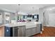 Modern kitchen island with a farmhouse sink, dishwasher, and elegant pendant lighting at 11808 Venture Oak Way, Raleigh, NC 27613