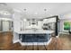 Bright kitchen features a large island with seating, stainless steel appliances, and hard wood floors at 11808 Venture Oak Way, Raleigh, NC 27613