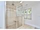 Bright bathroom featuring a glass enclosed shower with pebble floor and a built in bench at 1203 Queensbury Cir, Durham, NC 27713