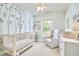 Light and airy Bedroom with a crib, glider, and woodland themed wallpaper at 1203 Queensbury Cir, Durham, NC 27713