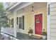 Welcoming front porch with rocking chairs and a bright red door, offering a cozy and inviting entrance at 1203 Queensbury Cir, Durham, NC 27713