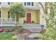 Inviting front porch with a brick walkway, flower beds, and a cozy seating area, perfect for relaxing at 1203 Queensbury Cir, Durham, NC 27713