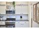 Kitchen with modern appliances, stylish backsplash, and bright white cabinets for ample storage at 1203 Queensbury Cir, Durham, NC 27713
