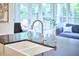 Kitchen with large farmhouse sink, stainless faucet, and a view into the cozy Gathering room at 1203 Queensbury Cir, Durham, NC 27713