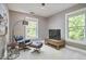 Cozy room with an accent chair and ottoman with a TV and natural lighting at 1203 Queensbury Cir, Durham, NC 27713