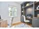 Home office space with custom built-ins, desk, shelves, and a window view at 1203 Queensbury Cir, Durham, NC 27713