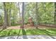 A backyard playground with a wooden fence, complimented by a gravel pathway and grass at 1203 Queensbury Cir, Durham, NC 27713