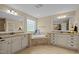 Luxurious bathroom featuring dual vanities, granite countertops, and a central tub, creating a spa-like retreat at 1209 Kingston Ridge Rd, Cary, NC 27511