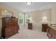Bedroom with matching wooden dressers, a neutral palette, and natural light streaming through the window at 1209 Kingston Ridge Rd, Cary, NC 27511