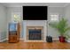 Living room with a stone fireplace and a large television mounted above it at 1209 Kingston Ridge Rd, Cary, NC 27511