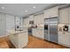 Well-appointed kitchen featuring stainless appliances, granite countertops, a center island, and hardwood floors at 1209 Kingston Ridge Rd, Cary, NC 27511