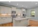 Gourmet kitchen with a center island, stainless steel appliances, granite countertops, and custom cabinetry at 1209 Kingston Ridge Rd, Cary, NC 27511