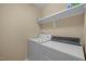 Compact laundry room with white appliances and a shelf, perfect for efficient laundry tasks at 1209 Kingston Ridge Rd, Cary, NC 27511