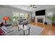 Cozy living room with hardwood floors, a stone fireplace, and large windows for plenty of natural light at 1209 Kingston Ridge Rd, Cary, NC 27511