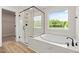 Bright bathroom features shower, tub, and large window at 1302 Cricket St, Elon, NC 27244