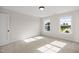 Sunny bedroom with neutral carpet and paint features bright windows at 1302 Cricket St, Elon, NC 27244