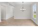 Bright dining room featuring wood floors, modern chandelier, and large window with natural light at 1302 Cricket St, Elon, NC 27244