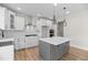 Modern kitchen with an island, stainless steel appliances, stylish pendants, and ample cabinet space at 1302 Cricket St, Elon, NC 27244