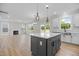 Open concept kitchen and living room featuring an island, fireplace, and wood flooring at 1302 Cricket St, Elon, NC 27244
