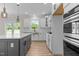 Stylish kitchen with an island, stainless steel appliances, bright cabinets, and wood flooring at 1302 Cricket St, Elon, NC 27244