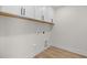 Functional laundry room features overhead cabinets, a utility sink, and laminate floors at 1302 Cricket St, Elon, NC 27244