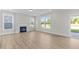 Bright living room features hardwood floors, a fireplace, and large windows with a view to the outdoors at 1302 Cricket St, Elon, NC 27244
