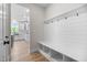 Bright mudroom features shiplap wall with hooks and built-in bench with cubbies, leading to the kitchen at 1302 Cricket St, Elon, NC 27244