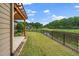 Pond view backyard features a well-kept lawn, rod iron fence and a covered patio with pergola and fan at 1305 Chronicle Dr, Durham, NC 27703