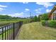 Lush backyard features a well-maintained lawn, mature trees, and a wooden pergola that covers the patio at 1305 Chronicle Dr, Durham, NC 27703