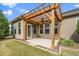 Covered patio features a wooden pergola with ceiling fan, offering an ideal space for outdoor relaxation at 1305 Chronicle Dr, Durham, NC 27703