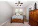 Inviting bedroom featuring carpeted floors, two windows, ceiling fan, and a vintage-style dresser at 1305 Chronicle Dr, Durham, NC 27703