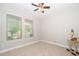 Cozy bedroom featuring two windows, plush carpeting, a ceiling fan and an end table at 1305 Chronicle Dr, Durham, NC 27703